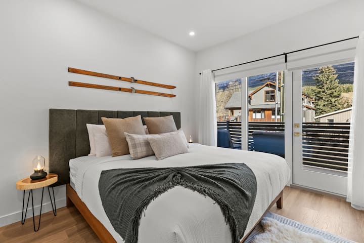 חדר שינה ראשי מואר ורענן עם מזרן קינג סייז יוקרתי וכריות ומצעים של מלון