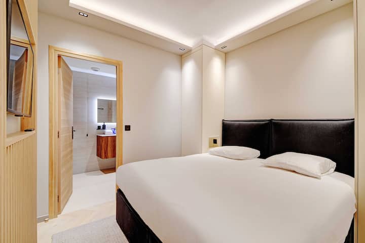 Dormitorio con cama matrimonial, espacio de almacenamiento y televisión
