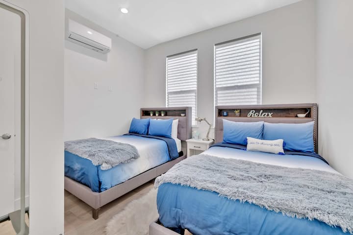 非常适合与家人或朋友入住！ 这间宽敞的卧室配备两张舒适的标准双人床、定制床头板和舒缓的海岸蓝色床上用品。