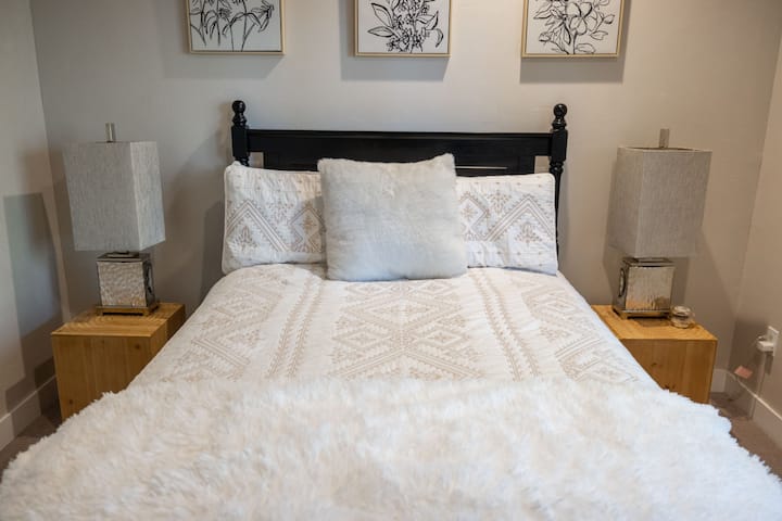 استمتع بالنوم في هذه الغرفة الهادئة مع فراش ناعم وإضاءة دافئة.