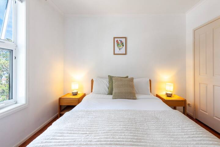 Štýlová a pokojná spálňa s prirodzeným svetlom, ktorá ponúka pokojné a pohodlné útočisko.