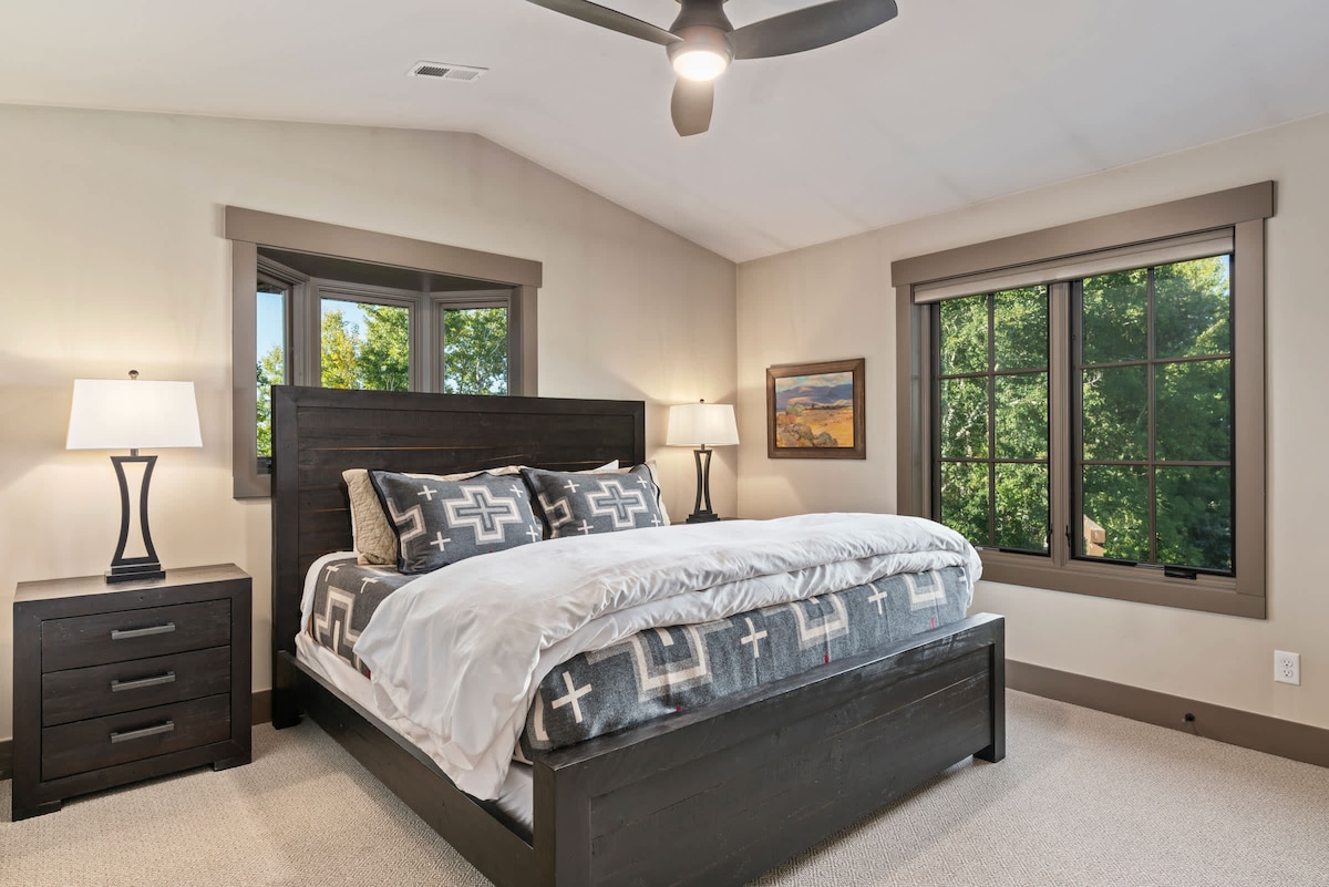 El dormitorio n.º 3 se encuentra arriba con una cama tamaño king, muebles de madera oscura y ropa de cama acogedora de Pendleton.