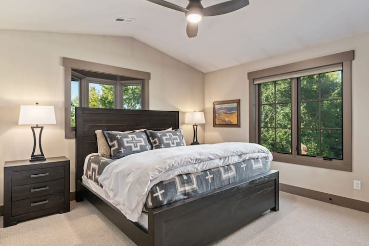 El dormitorio #3 se encuentra arriba con una cama tamaño king, muebles de madera oscura y ropa de cama acogedora de Pendleton.