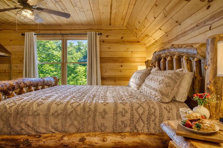 Chambre king size de niveau supérieur avec lit en rondins authentique et linge de lit de luxe : votre retraite privée pour des nuits reposantes dans les montagnes.