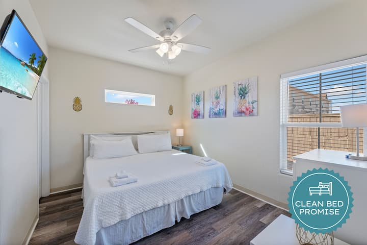 Sumérgete en la comodidad de este luminoso dormitorio con sábanas limpias, obras de arte tropicales y tu propio ventilador de techo para un control perfecto de la temperatura.