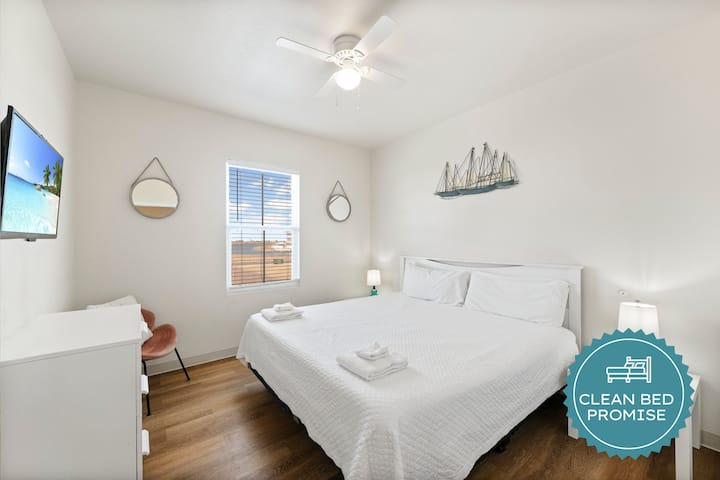 Descansa tranquilamente en tu luminoso dormitorio con sábanas frescas, toques náuticos y un ventilador de techo refrescante.