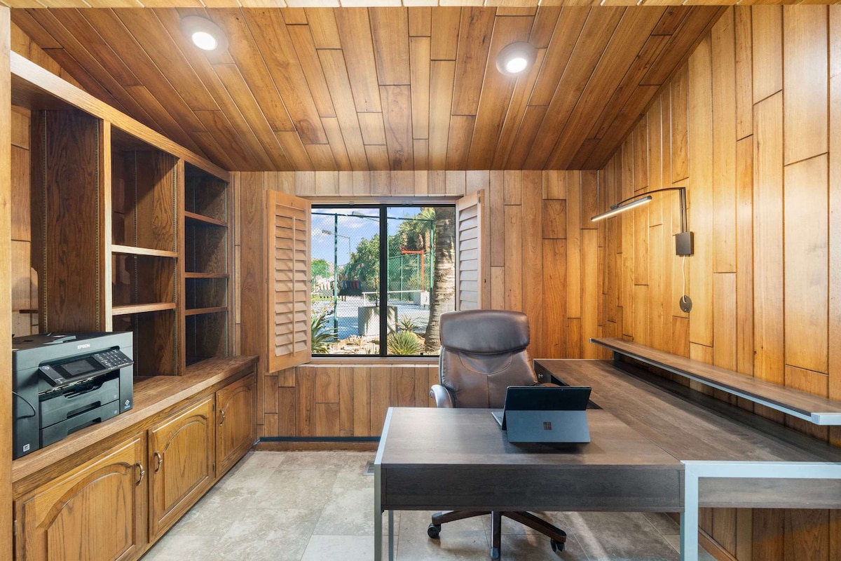 مكتب جناح أساسي مع مكتب وطابعة لاسلكية بالإضافة إلى إطلالات على الحديقة