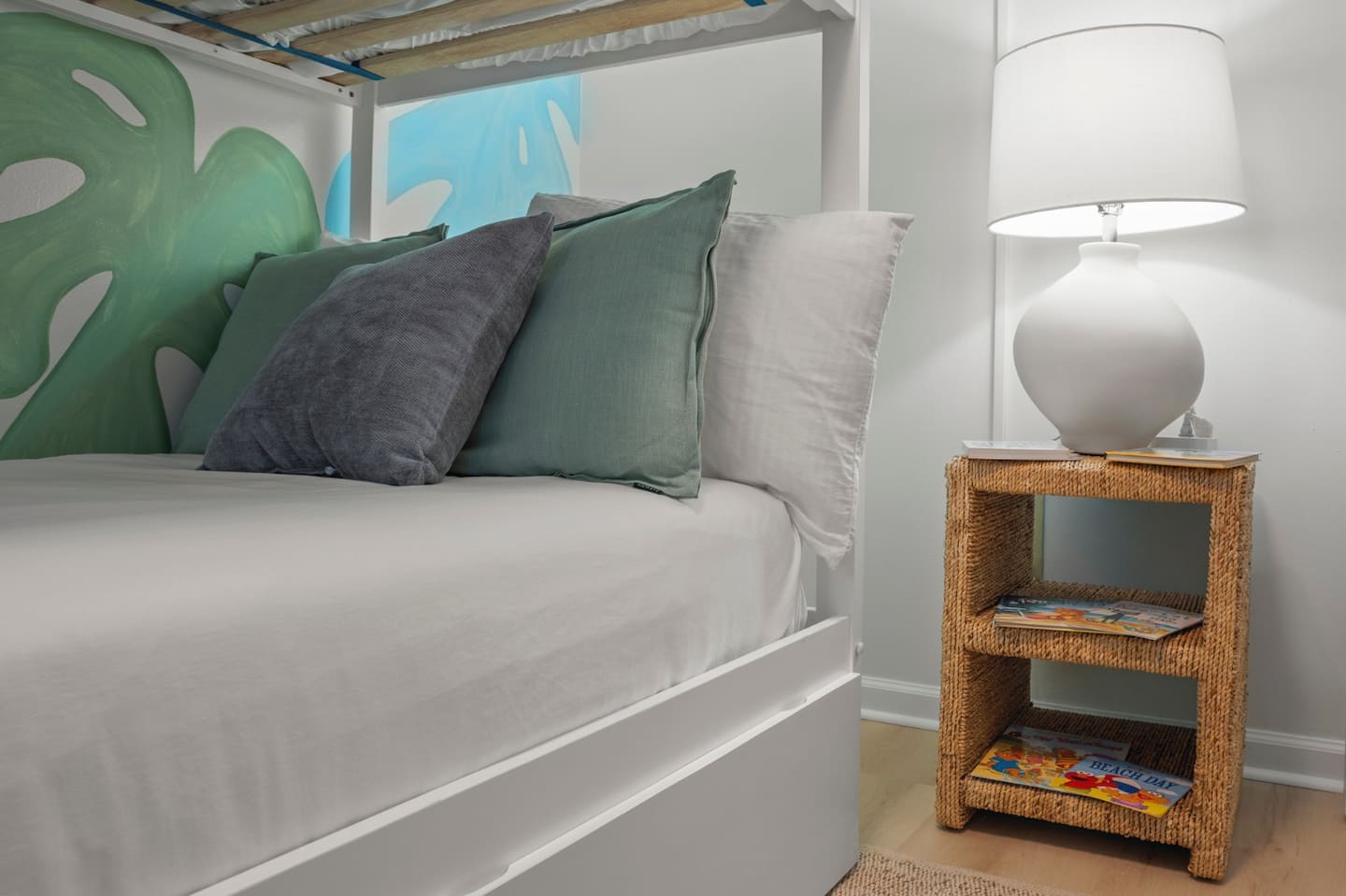 Sink into soft pillows and drift off beneath calming tropical tones, where cozy textures and gentle lighting end a beach-filled day perfectly.