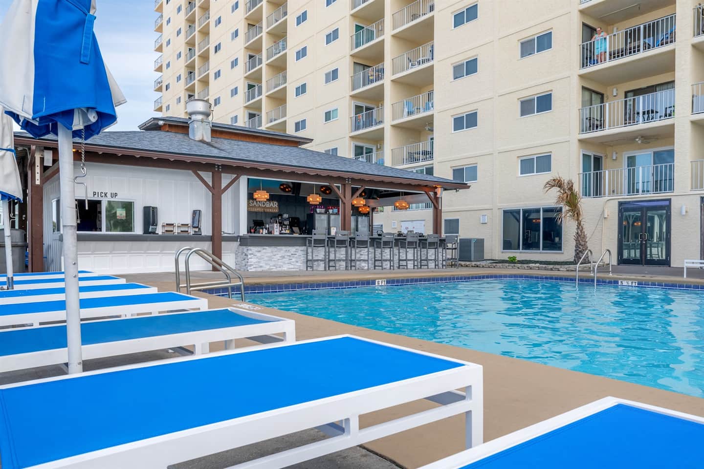 The community pool deck by day, with loungers for guests of the building