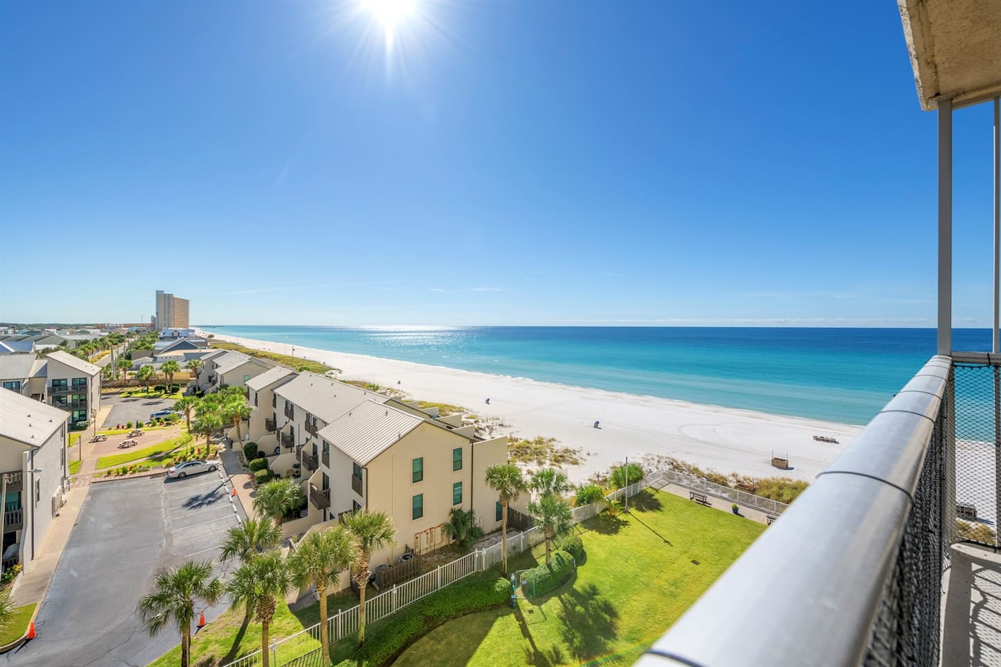 Balcony-view aerial down the Gulf coastline, showing the building's beachfront setting