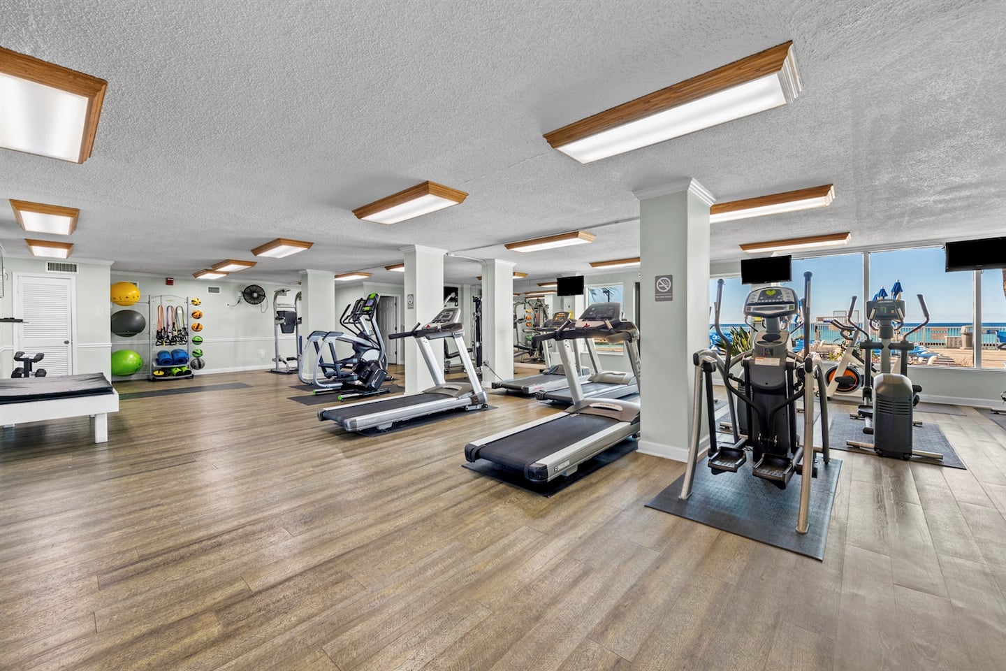 The building's shared fitness center, with a Gulf view through the window wall