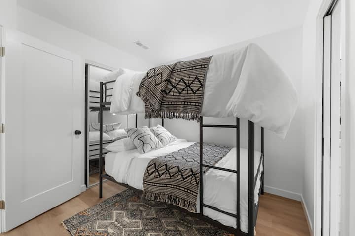 Táto svetlá izba s poschodovými lôžkami je vybavená útulnou posteľnou bielizňou, boho textíliami a zrkadlovými dverami skrine – ideálna pre rodiny alebo priateľov. Zábavný a funkčný priestor v Crown Point Airbnb len kúsok od zálivu.