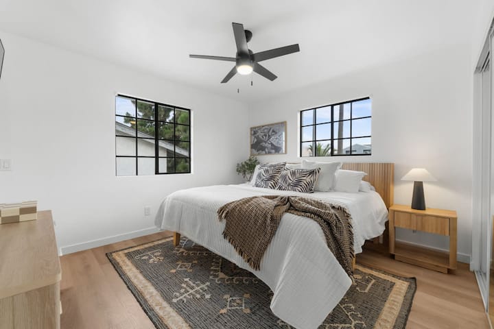 Oddýchnite si v tejto svetlej, vzdušnej spálni s manželskou posteľou, boho-chic dekoráciami a veľkými oknami s výhľadom na palmy San Diega. Pokojný priestor v tomto modernom Crown Point Airbnb – len kúsok od zálivu.