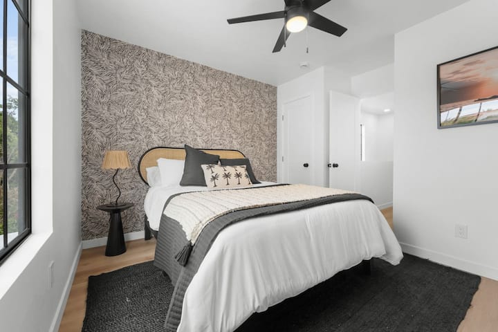 Táto štýlová izba pre hostí má manželskú posteľ, stenu s tropickým motívom a moderný boho dekor. Útulné útočisko v tomto Airbnb Crown Point – ideálne na dobitie energie po slnečnom dni v San Diegu v blízkosti zálivu.