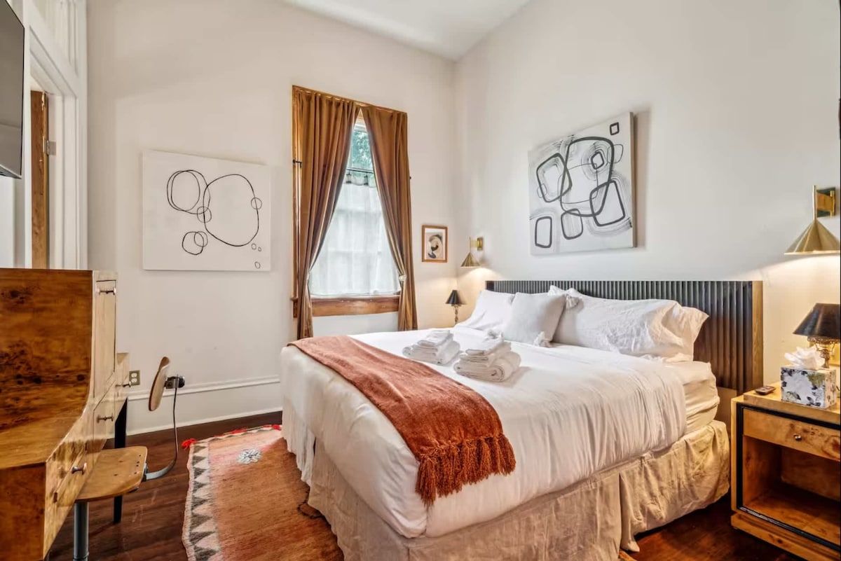 温馨的特大号卧室，配有柔软的纹理、现代艺术品和温暖的自然色调，让您轻松入睡。