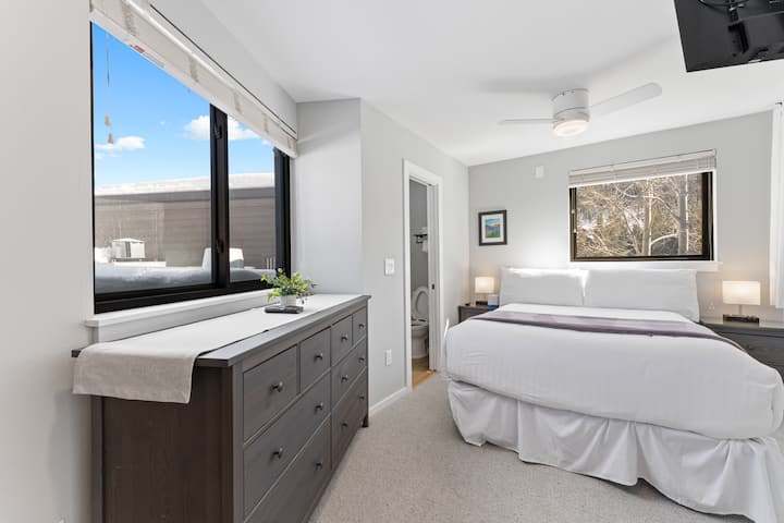 Hlavná spálňa s manželskou posteľou, vlastnou toaletou, televízorom s plochou obrazovkou a veľkými oknami na všetkých stranách. 