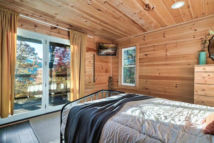 Chumba cha kulala chenye kitanda cha malkia kilichowekwa mbali kwa faragha kwenye ghorofa ya chini.