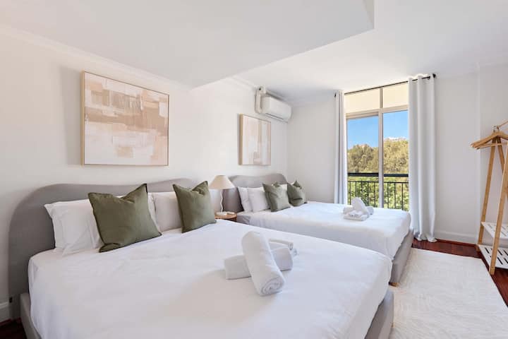  ห้องนอนเตียงคู่:
ห้องนอนขนาดใหญ่พร้อมเตียงควีนไซส์ 2 เตียงที่มีผ้าปูที่นอนหรูหราและหมอนอิงสีเซจ เหมาะสำหรับครอบครัวหรือเพื่อน มีระบบควบคุมอากาศ พื้นไม้ขัดเงา และวิวระเบียงที่มีแสงธรรมชาติ