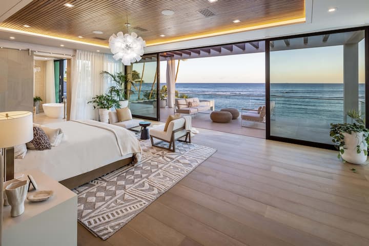 Wake up to breathtaking Pacific views from the primary bedroom, complete with a private lanai and seating.