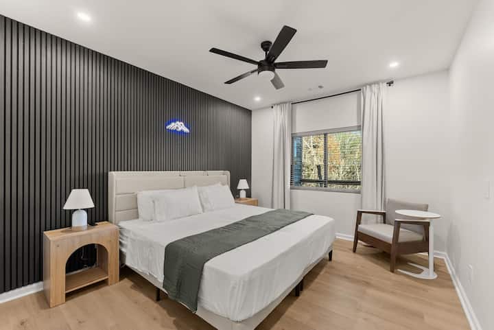 Dos camas individuales flexibles que se pueden convertir en una cama tamaño king o permanecer separadas, con mesitas de noche modernas, paneles de pared y un espacioso armario, elegante y adaptable para cualquier estancia.