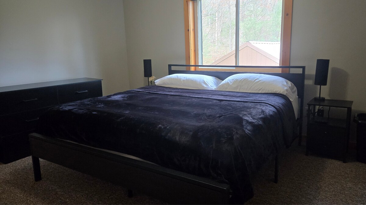 Hlavná spálňa s manželskou posteľou, komodou, šatníkom, zrkadlom a televízorom.