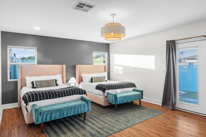 חדר שינה ראשי מוכן לקבוצת הזוהר עם שתי מיטות קווין סייז ושירותים מלאים להתכוננות למצלמה.