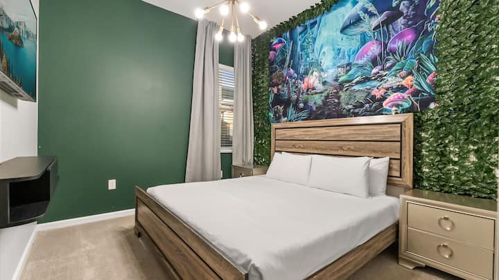 Dormitorio 2 – Tranquila suite con cama tamaño king con mural inspirado en el bosque e iluminación suave.