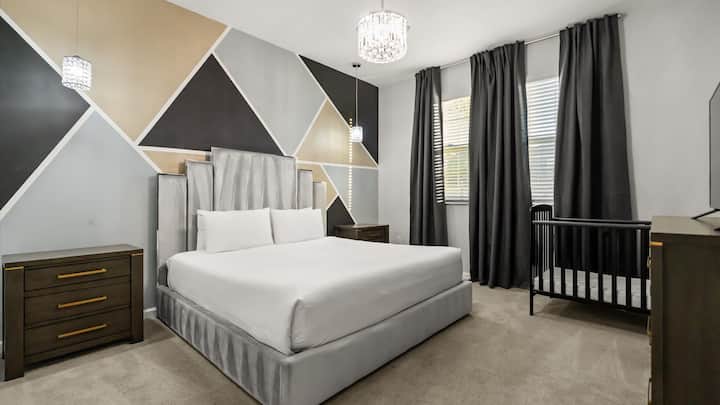 Dormitorio 4 – Habitación king contemporánea con diseño de pared geométrico y cortinas opacas.