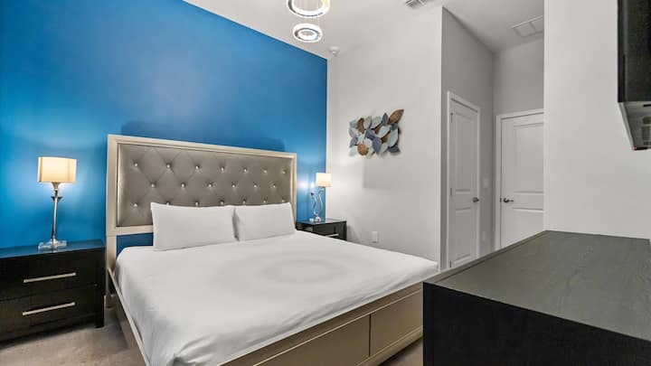 Dormitorio 1: dormitorio luminoso con cama tamaño king, pared azul relajante y televisor inteligente.