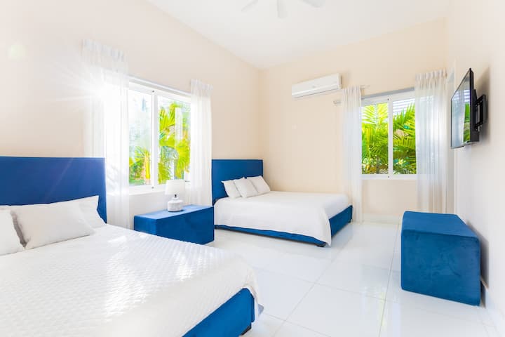 Chambre spacieuse avec lits jumeaux et vue sur le jardin.