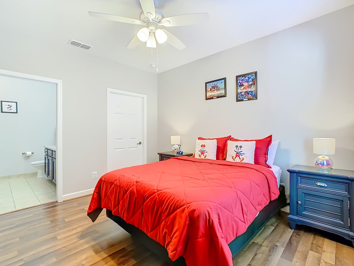 Útulná spálňa s farebnou posteľnou bielizňou a množstvom prirodzeného svetla.