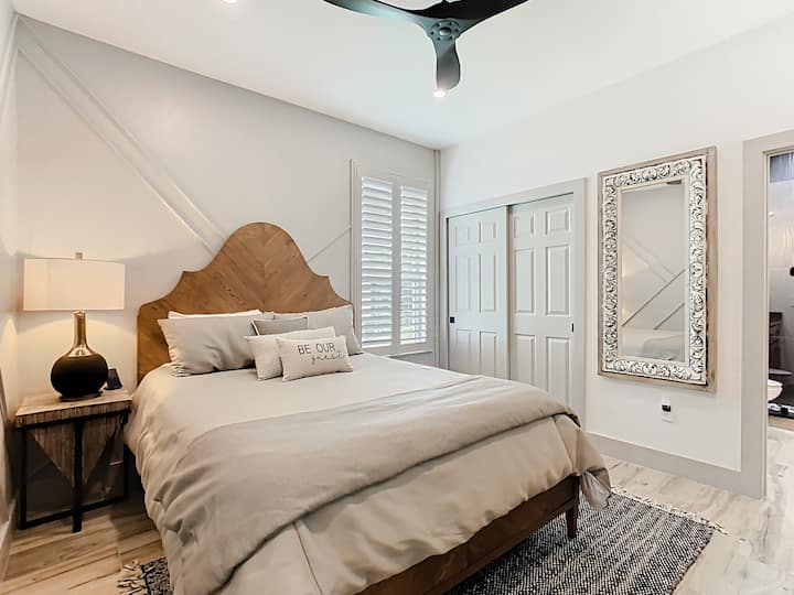 Ugodna spavaća soba s velikim ogledalom, udobnom posteljinom i prostranim ormarom.