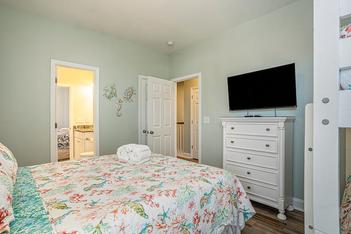 Profitez d'un séjour confortable dans cette chambre avec grand lit, ses fenêtres lumineuses et son style côtier moderne.