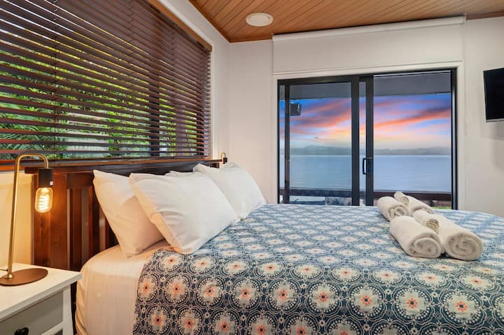 Chumba Kikuu cha Kulala chenye mandhari ya kuvutia ya ziwa pamoja na bafu la chumbani.