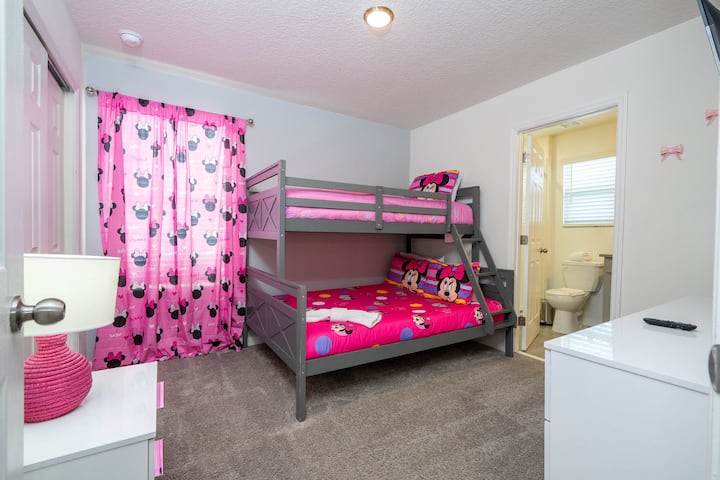 Paraíso con temática de Minnie con una litera doble, alegres detalles en rosa y un baño a pocos pasos, ¡perfecto para los niños!
