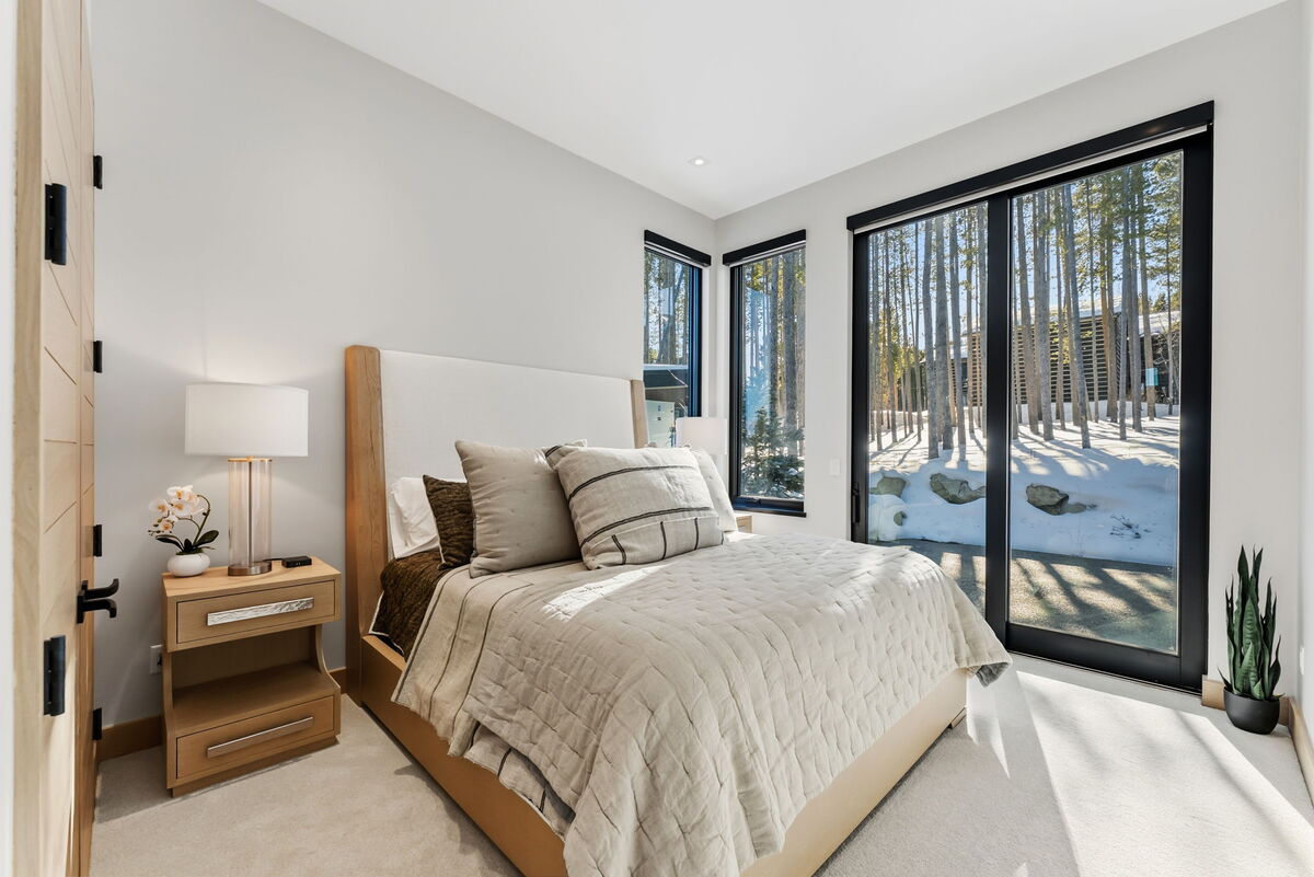 Habitación con cama tamaño king en el piso principal: suite con cama tamaño king iluminada por el sol junto a la sala de estar con vistas a Breckenridge, TV y baño privado.