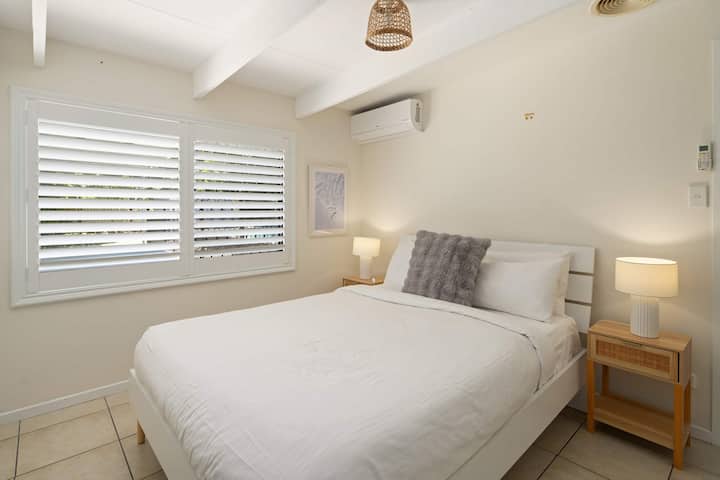 Retírate a la comodidad del dormitorio principal, donde una cama tamaño queen, una suave luz natural y tonos relajantes crean un final tranquilo para cada día.