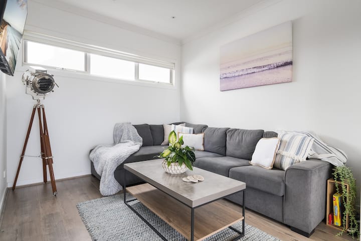 Дневна соба со паметен телевизор и кауч на кој може да се спие