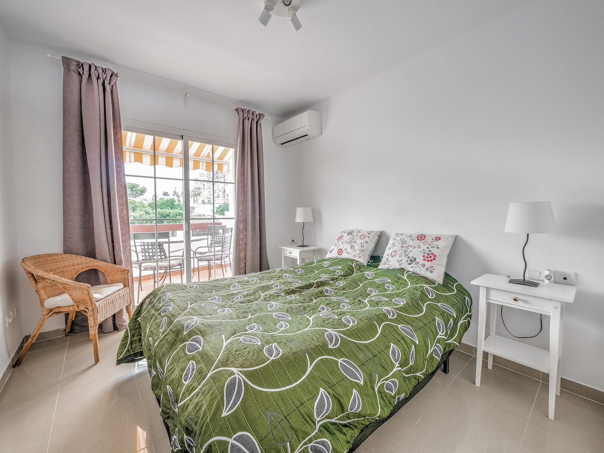 Chambre principale avec climatisation, lit double et balcon.