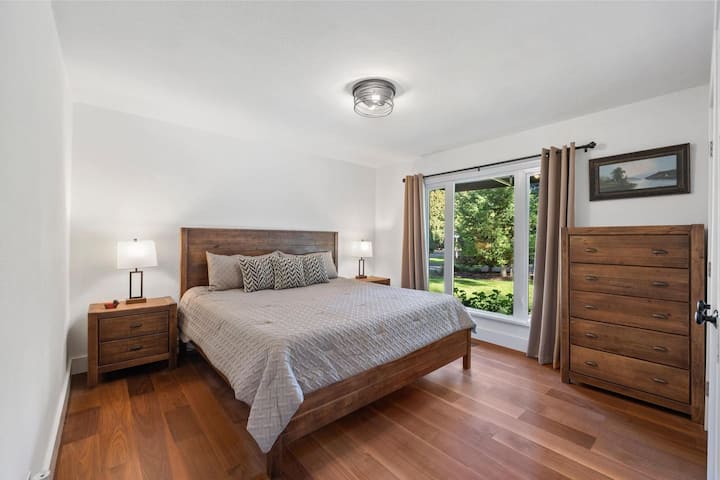 Спалня с голямо двойно легло с топъл, модерен декор и много място за съхранение.