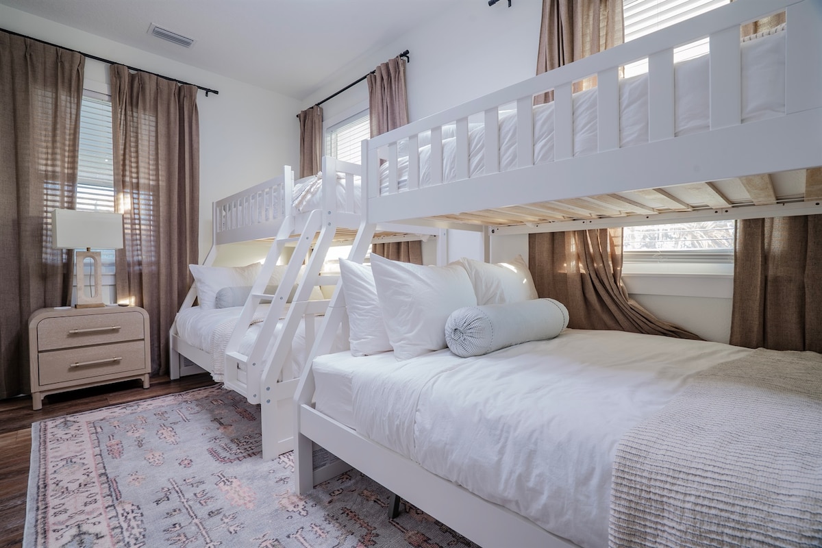 Dhomë me krevate marinari e ndërtuar për rehati — çarçafë të bardhë dhe hapësirë ruajtjeje pranë krevatit për të gjithë