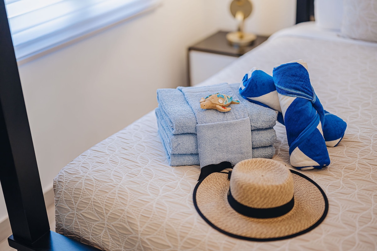 Master Suite 2 en The Tides con una cama tamaño king, sábanas de estilo y tonos isleños relajados.