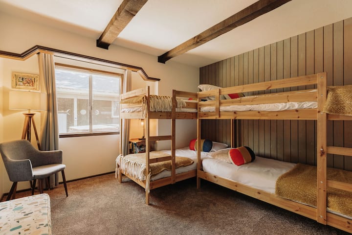 Dormitorio de invitados con literas dobles y TV