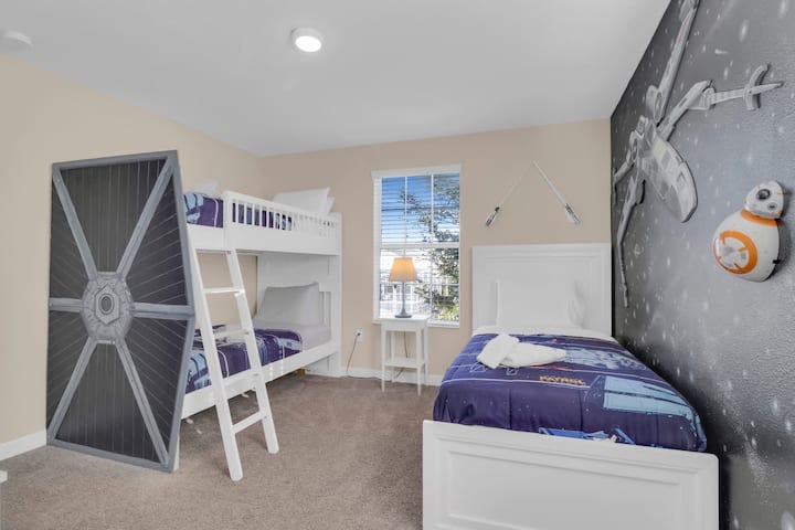 Space-themed bedroom with bunk bed and single bed.