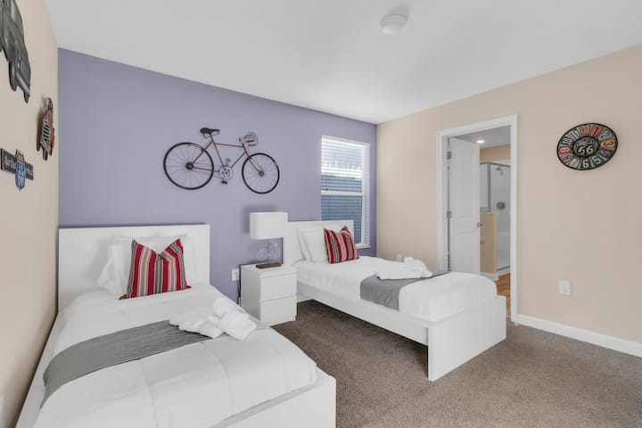 Twin bedroom with two beds and bicycle wall decor.