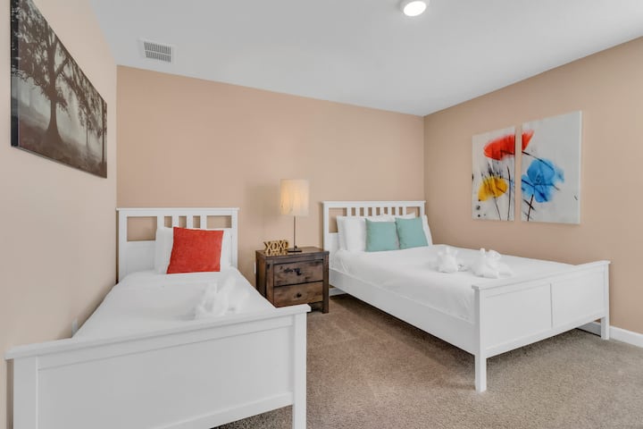 Twin bedroom with two beds, nightstand, and colorful artwork.