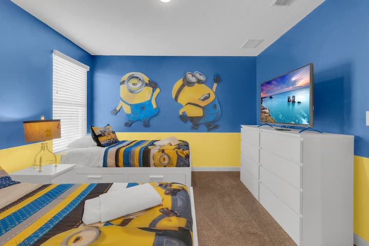 Kids bedroom with twin beds and Minions-themed wall decor.