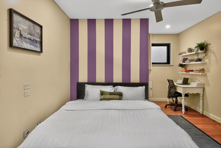 Udobna spavaća soba s upečatljivim zidom + radnim stolom, stropnim ventilatorom