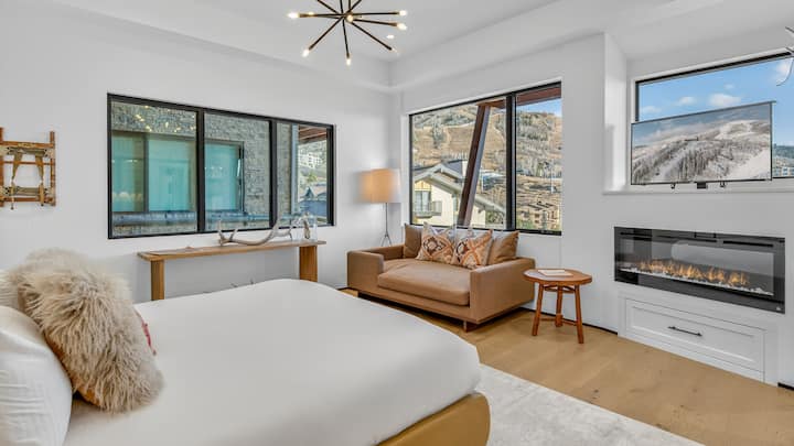 Habitación 1, planta principal: suite principal con cama king, chimenea y vistas a las montañas