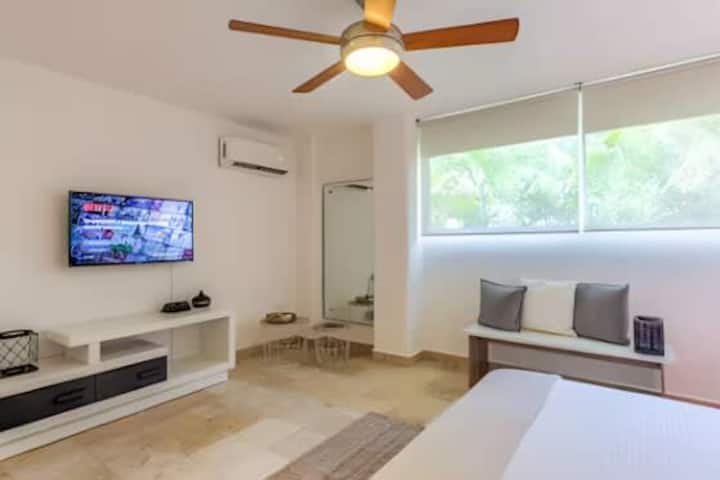 ห้องนอนที่สะดวกสบายพร้อมเตียง ทีวี และหน้าต่างกว้างที่ให้แสงแดดส่องเข้ามาได้มาก